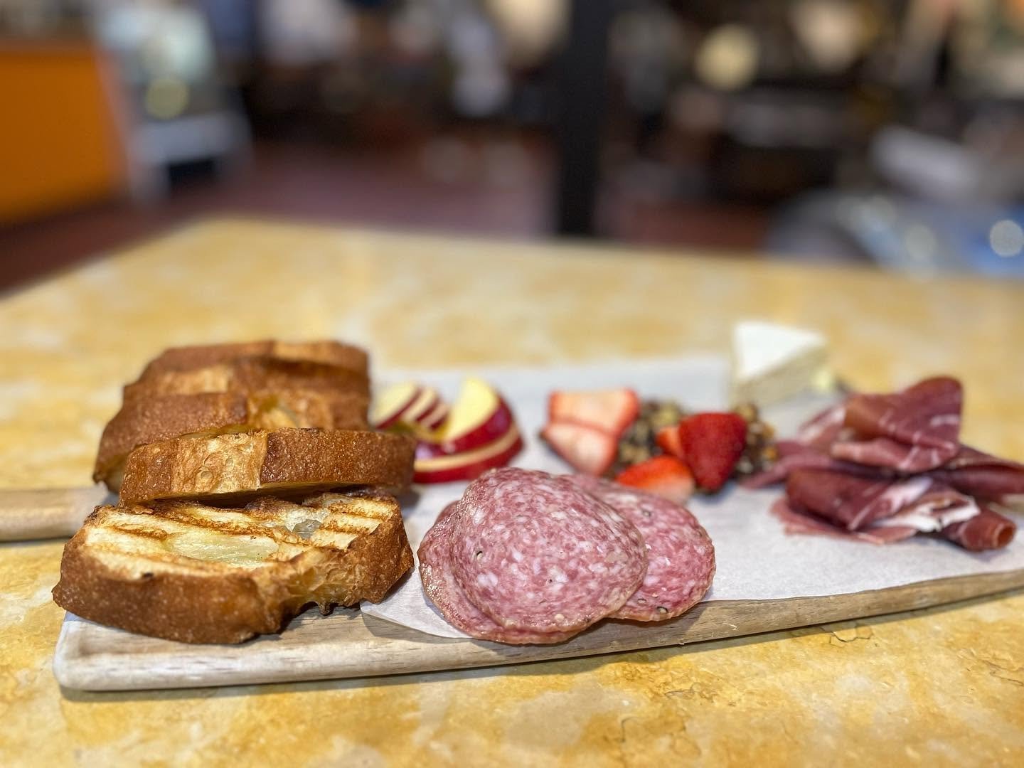 Charcuterie board with salami, prosciutto, brie and grilled bread